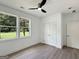 A light and airy bedroom with wood laminate flooring, closet, ceiling fan, and large windows at 243 Roxbury Dr, Riverdale, GA 30274