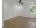 A light and airy bedroom with wood laminate flooring and large window at 243 Roxbury Dr, Riverdale, GA 30274
