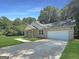 Charming single-story brick home featuring a two-car garage, manicured lawn, and inviting curb appeal at 243 Roxbury Dr, Riverdale, GA 30274