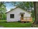 Rear exterior showing a white house with a wooden deck, dark trim, and green grass at 4451 Flat Shoals, Decatur, GA 30034