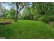 Expansive green backyard with mature trees, a large grassy area, and a wooden deck attached to the house at 4451 Flat Shoals, Decatur, GA 30034