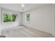Bright bedroom features light wood-look floors, large windows overlooking a green yard, and neutral decor at 4451 Flat Shoals, Decatur, GA 30034