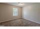 A well-lit bedroom with a neutral color scheme and plush carpet, featuring a window at 6200 Beaver Creek Trl, Atlanta, GA 30349