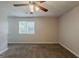 Spacious bedroom featuring plush carpet, a ceiling fan, and ample natural light from large windows at 6200 Beaver Creek Trl, Atlanta, GA 30349