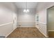 Charming dining area features neutral walls, carpet, and classic chandelier lighting at 1105 Buckhurst Dr, Atlanta, GA 30349