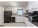 Traditional kitchen features white cabinets, black appliances, and durable tile flooring at 1105 Buckhurst Dr, Atlanta, GA 30349