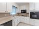 Bright kitchen with white cabinetry, black appliances, and tiled floors providing a clean look at 1105 Buckhurst Dr, Atlanta, GA 30349
