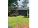 Cozy backyard features a wooden deck, green lawn, and mature trees at 176 Avalon Way, Riverdale, GA 30274