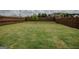 Expansive backyard with lush green grass and a full wooden fence; perfect for outdoor activities at 2159 Redfern, Dacula, GA 30019