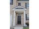 Close-up of a charming entryway with a welcome sign, decorative brick, and a black front door at 2159 Redfern, Dacula, GA 30019