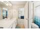 Bright bathroom with a tiled floor, white vanity, and shower-tub combo adjacent to a bedroom at 826 Richmond Cir, Peachtree City, GA 30269