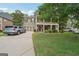 Traditional two-story home with a well-manicured lawn, multiple vehicles, and an inviting exterior at 826 Richmond Cir, Peachtree City, GA 30269