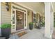 Charming front porch with rocking chairs, plants, 'hello' door mat, and a door with a 'Braves' wreath at 826 Richmond Cir, Peachtree City, GA 30269