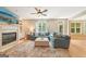 Cozy living room featuring a fireplace, ceiling fan, and natural light at 826 Richmond Cir, Peachtree City, GA 30269
