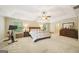 Spacious main bedroom featuring tray ceilings, a ceiling fan, carpet, and a large bed, dresser and workout bike at 826 Richmond Cir, Peachtree City, GA 30269