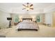 Spacious main bedroom featuring tray ceilings, a ceiling fan, carpet, and a large bed, with lots of natural light at 826 Richmond Cir, Peachtree City, GA 30269