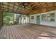 Large screened porch with wood flooring, exposed rafters, and ceiling fans; perfect for outdoor entertaining at 3123 Deshong Dr, Stone Mountain, GA 30087