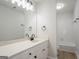 Bright bathroom featuring a large mirror, white vanity and shower-tub combo with white tile at 5674 Mountain Cres, Stone Mountain, GA 30087