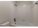 White tiled shower-tub combo featuring a black shower head, with a toilet in the corner at 5674 Mountain Cres, Stone Mountain, GA 30087