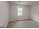 Carpeted bedroom featuring a window with backyard views and neutral paint at 5674 Mountain Cres, Stone Mountain, GA 30087