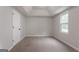 Neutral bedroom featuring soft carpet, a bright window, and a tray ceiling at 5674 Mountain Cres, Stone Mountain, GA 30087