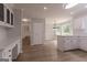 Open-concept kitchen and dining area with hardwood floors and updated light fixture at 5674 Mountain Cres, Stone Mountain, GA 30087