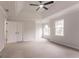 Carpeted main bedroom featuring tray ceilings, large windows and a walk-in closet at 5674 Mountain Cres, Stone Mountain, GA 30087