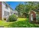 Landscaped backyard with wooden deck, white pergola, shed, and lush greenery at 901 Chadwick Park Dr, Lawrenceville, GA 30045