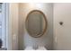 Well-lit powder room featuring an round mirror and simple decor at 901 Chadwick Park Dr, Lawrenceville, GA 30045