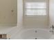 Bathroom with soaking tub, window, and neutral colored walls at 1006 Eagle Vw, Lawrenceville, GA 30044