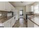 Well-lit kitchen featuring white cabinets, sleek appliances, and mosaic backsplash at 1006 Eagle Vw, Lawrenceville, GA 30044