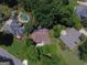 Aerial view of the home showcasing the backyard, pool, neighboring houses, and lush greenery at 11940 Wexford Club Dr, Roswell, GA 30075