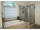 Modern bathroom with a glass-enclosed shower, a soaking tub, and beige tile at 11940 Wexford Club Dr, Roswell, GA 30075