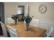 Dining room with a wooden table, six white chairs, and stylish plants on the table at 11940 Wexford Club Dr, Roswell, GA 30075