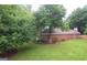 Home featuring lush lawn, mature trees, brick siding, roof, and landscape beds at 11940 Wexford Club Dr, Roswell, GA 30075