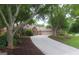 Brick home featuring a long driveway, well-maintained landscaping, mature trees, and a two-car garage at 11940 Wexford Club Dr, Roswell, GA 30075