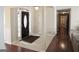 Inviting foyer with dark wood door, sidelights, tile flooring, and views of the hallway with hardwood floors at 11940 Wexford Club Dr, Roswell, GA 30075