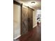 Hallway with rustic sliding barn doors and wood laminate flooring at 11940 Wexford Club Dr, Roswell, GA 30075
