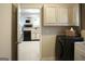 Laundry room featuring a black washer and dryer, white cabinets, and a view into the living area at 11940 Wexford Club Dr, Roswell, GA 30075