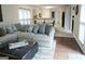 Cozy living room with a large sectional sofa, ottoman, and view into the kitchen and dining area at 11940 Wexford Club Dr, Roswell, GA 30075