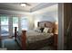 Spacious bedroom featuring hardwood floors, a large bed, and access to the outdoor patio at 11940 Wexford Club Dr, Roswell, GA 30075