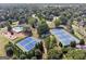 Aerial view of community tennis courts near swimming pool and playground in a lush, tree-filled neighborhood at 11940 Wexford Club Dr, Roswell, GA 30075