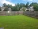Large, grassy backyard enclosed by a wooden fence, perfect for outdoor activities at 2424 Saint Andrews Rdg, College Park, GA 30337