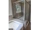 A tiled bathroom with a glass shower that has a window at 2424 Saint Andrews Rdg, College Park, GA 30337