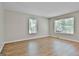 Bright bedroom with wood floors, neutral paint, base trim, and two windows bringing in natural light at 36 Cobblestone Crk, Peachtree City, GA 30269