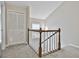 Hallway featuring carpeted floors, wood railing and a closet with white doors, providing ample storage and a cozy feel at 36 Cobblestone Crk, Peachtree City, GA 30269
