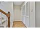 Hallway with wood-look flooring and a white closet door by a carpeted staircase at 36 Cobblestone Crk, Peachtree City, GA 30269