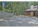 Wide view of the parking area and a stone retaining wall surrounded by mature trees and landscaping at 36 Cobblestone Crk, Peachtree City, GA 30269