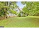 Spacious backyard with a white house and trees surrounding the green lawn at 936 Bo Bo Banks Rd, Grantville, GA 30220
