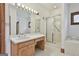 Bright bathroom featuring a shower with sliding glass door, tub, and vanity with Hollywood lights at 936 Bo Bo Banks Rd, Grantville, GA 30220